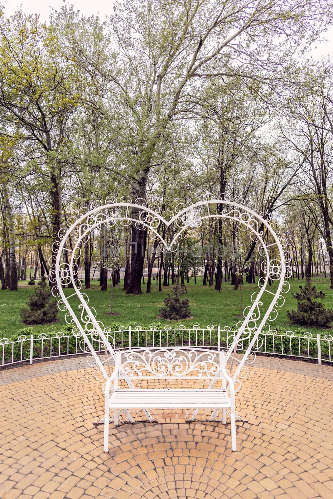 A white heart behind a bench to symbolize love, in the Natalka park of Kiev, Ukraine