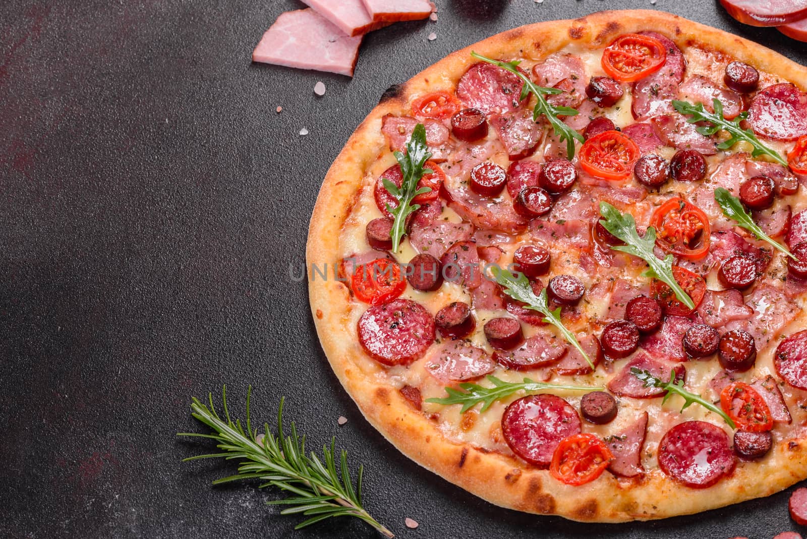 Pepperoni Pizza with Mozzarella cheese, salami, ham. Italian pizza on a dark background