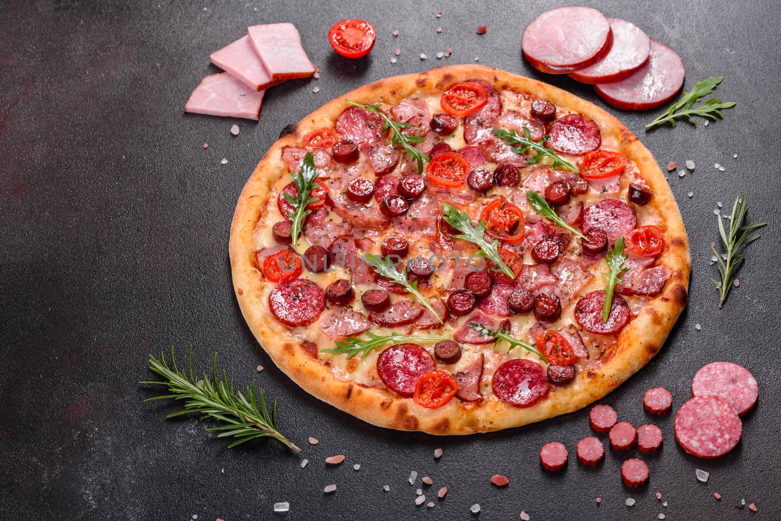 Pepperoni Pizza with Mozzarella cheese, salami, ham. Italian pizza on a dark background