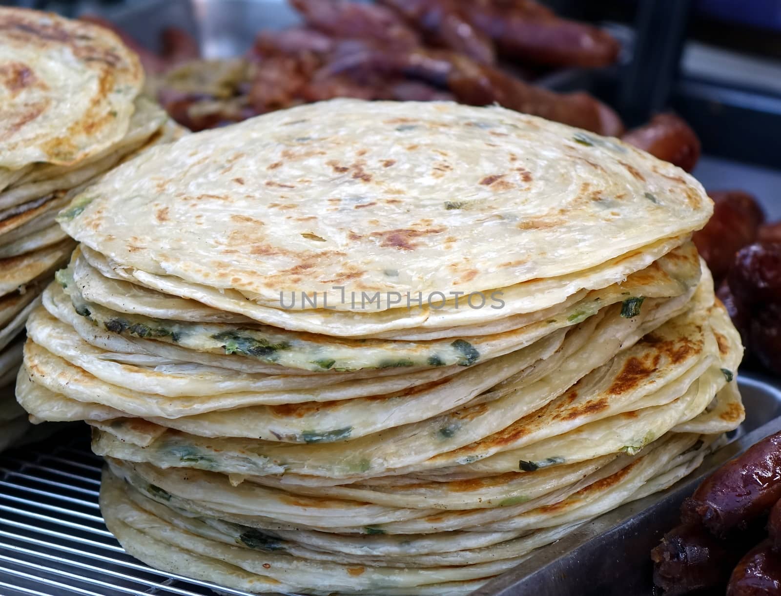 A street food stall offers fried pancakes with spring onions 
