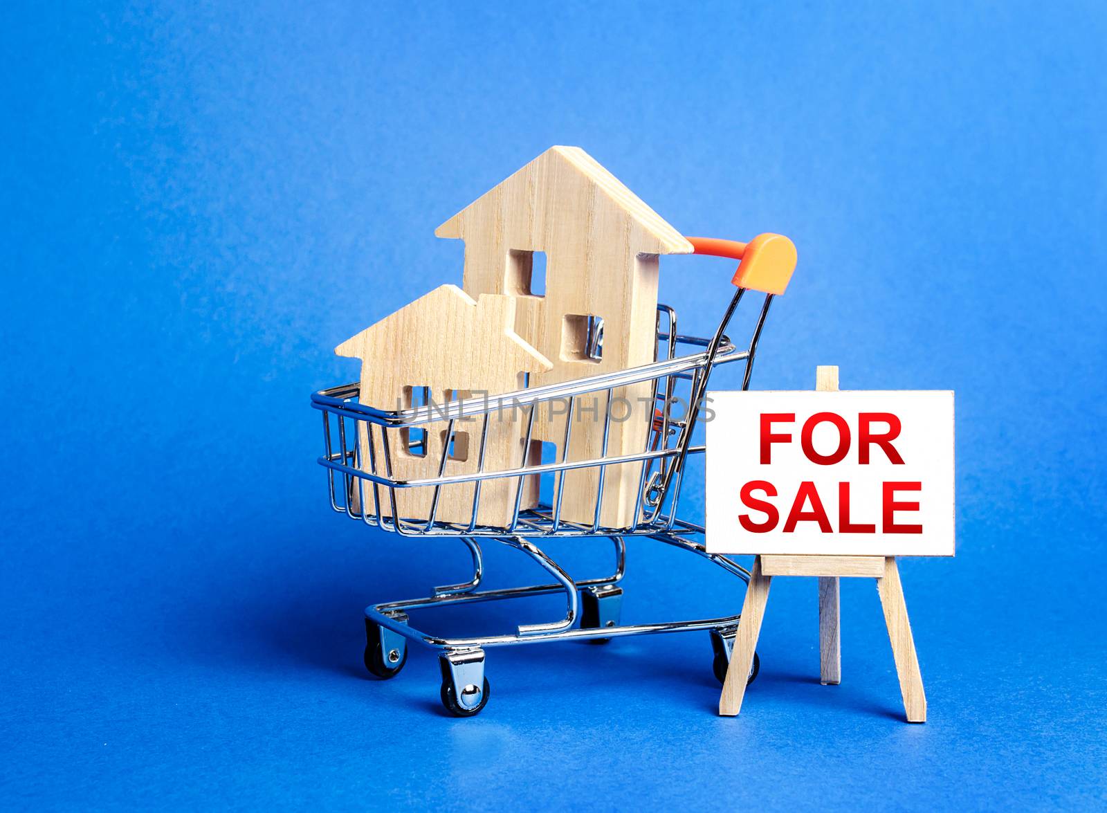 Houses in a shopping cart and an easel sign labeled for sale. Buying and selling real estate, hot offers and property valuation. Smart investments. Discounts and great offers, cheap loans for purchase by iLixe48