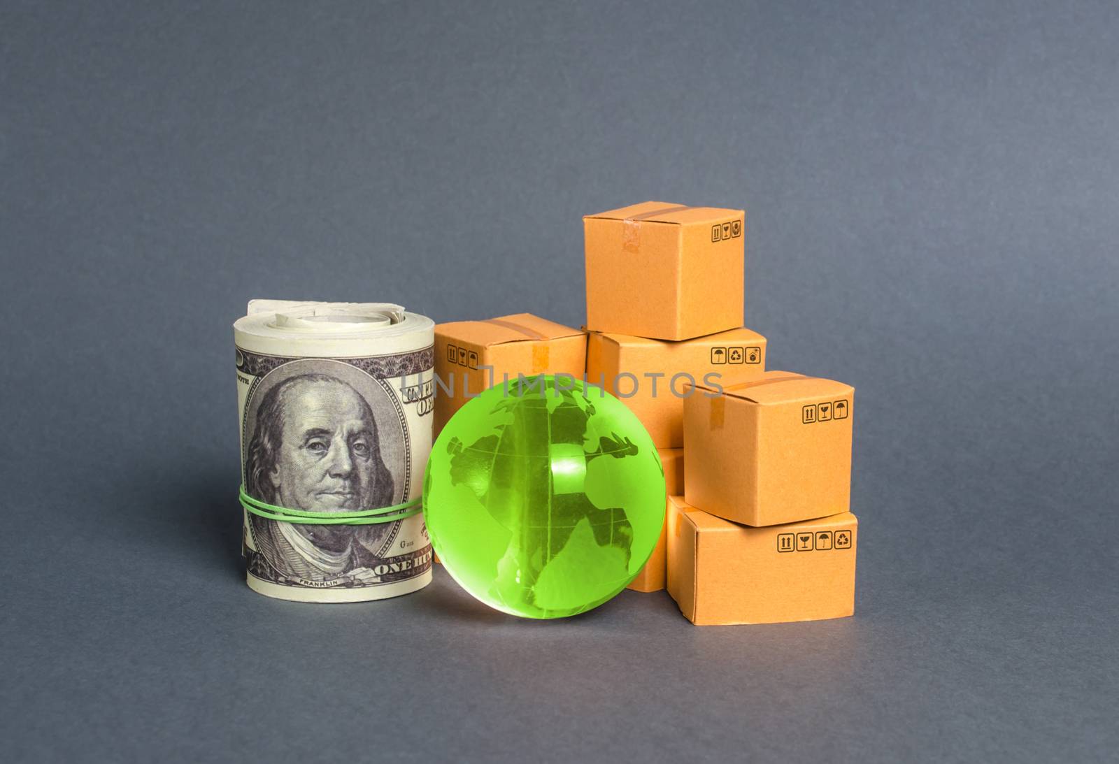 A stack of boxes, a bundle of dollars and a green planet earth globe. World trade and commodity exchange. commerce traffic trading balance. Import, export, transit of products. Economic relations.