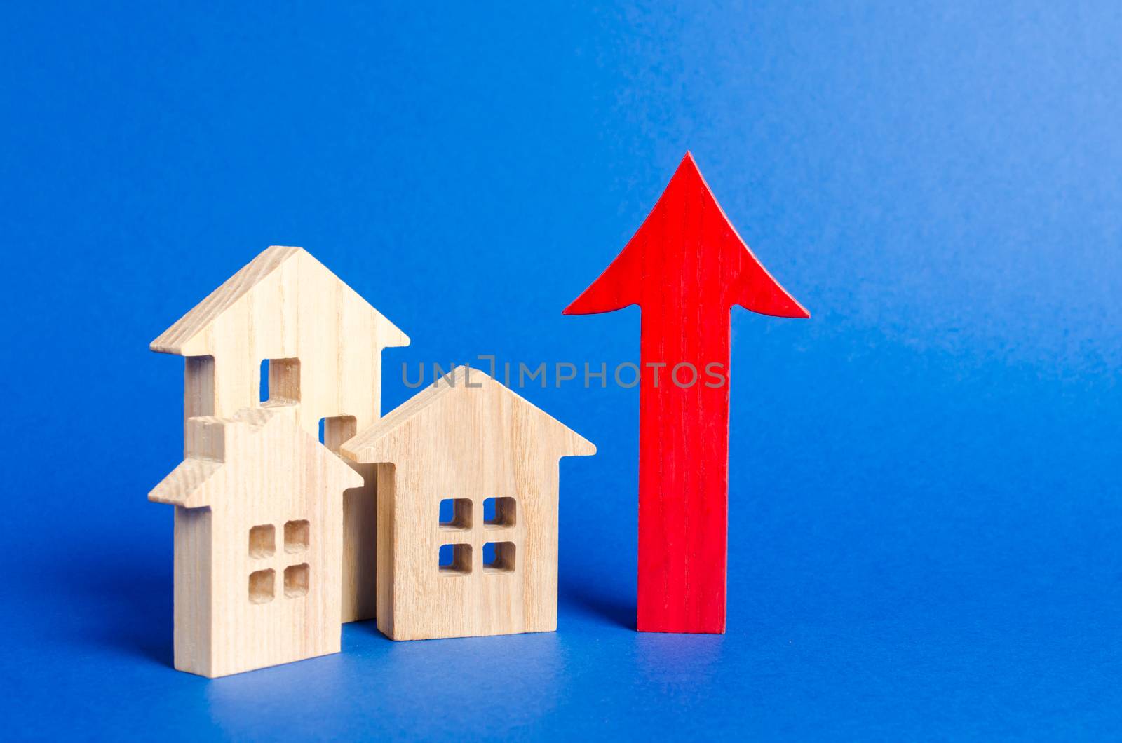 three wooden houses and red up arrow. Real estate value increase. High rates of construction, high liquidity. Supply and demand. prices for housing, building maintenance. limit on high-rise buildings