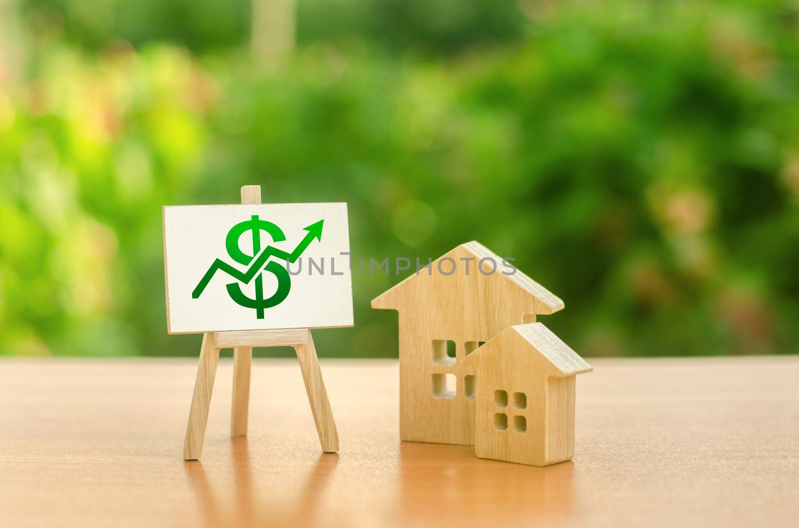 Two wooden houses and a green up arrow on the sign. Real estate value increase. Rising prices for housing, building maintenance. Supply and demand. High rates of construction, high liquidity.