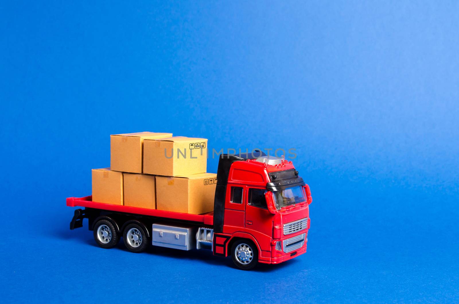 A red truck loaded with boxes. Services transportation of goods and products, logistics and infrastructure. Transportation company. Warehousing and supply. Optimization of delivery logistics.