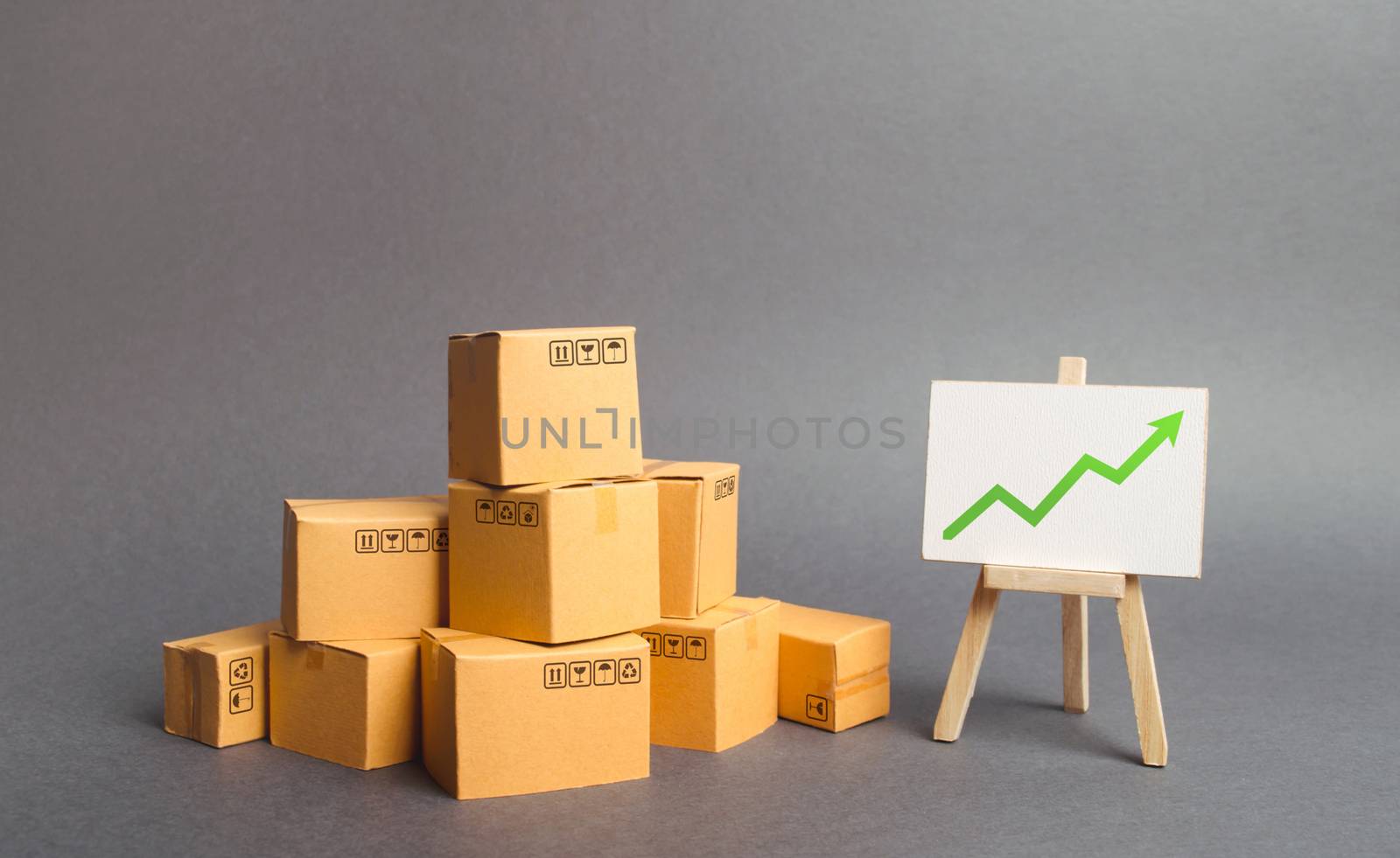 Plenty of cardboard boxes and whiteboard with green positive chart arrow up. Increasing consumer demand. rate growth of production of goods and products, increasing economic indicators.