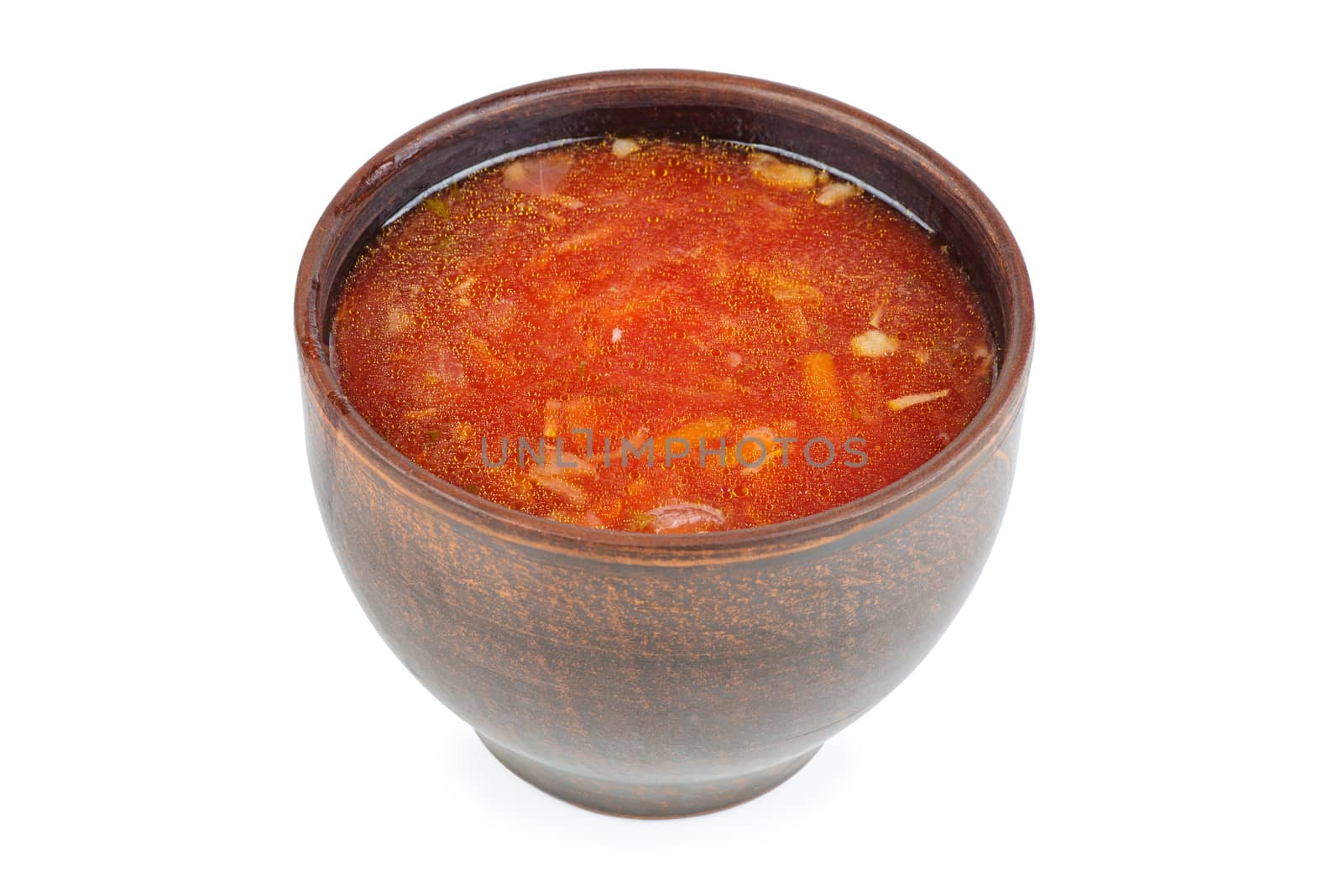 Clay bowl with traditional Ukrainian borscht (beet root soup) isolated on white background.