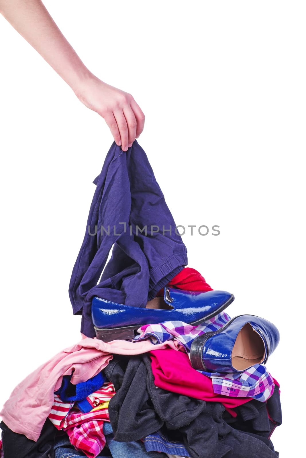 Hand put one item to pile of old used clothes isolated on white background