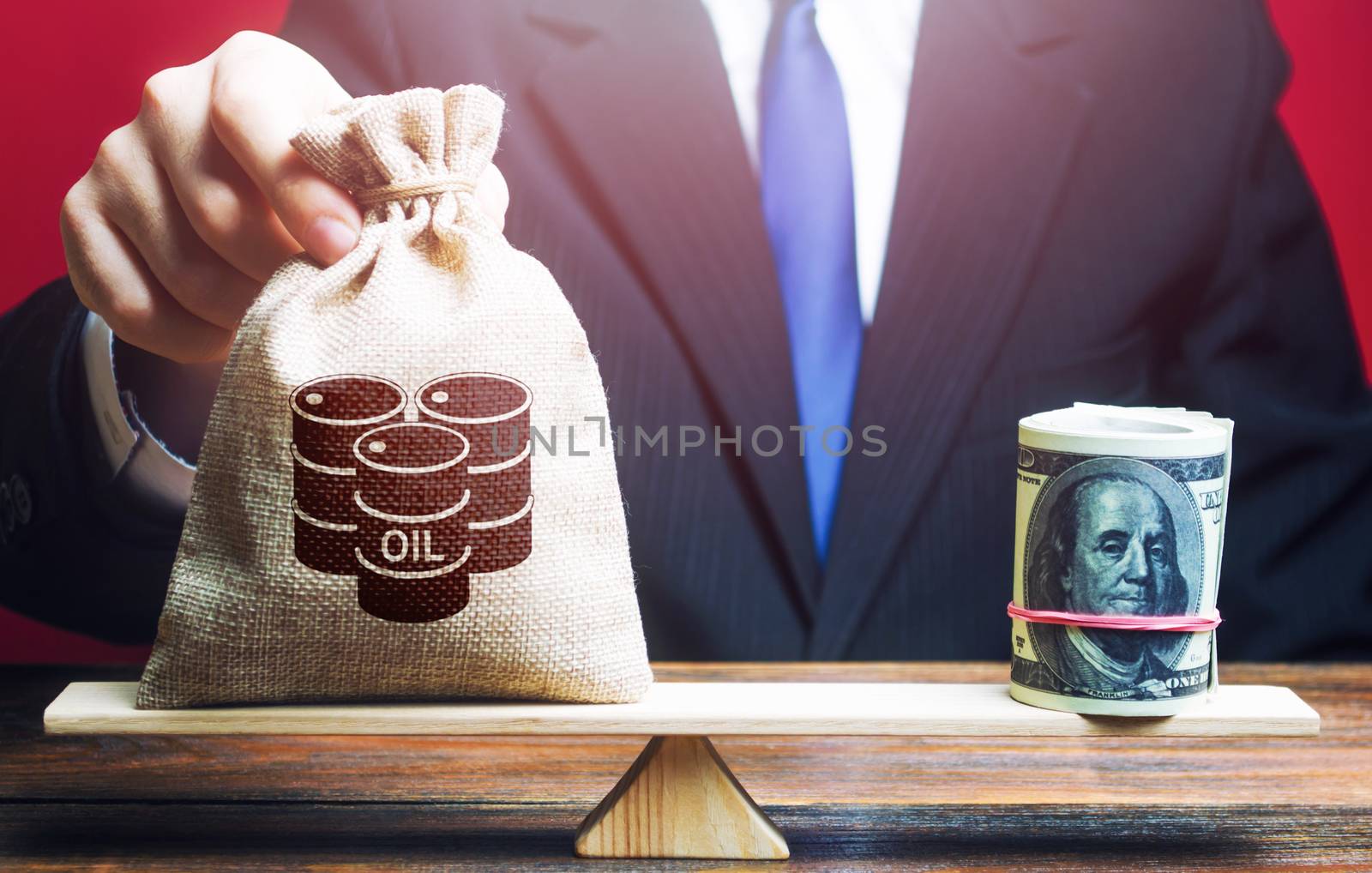 Man lays a bag with barrels of oil on his weight as opposed counterweight to dollars bundle roll. World pricing of oil. Cheap energy resources to restore economy. Market stabilization by iLixe48