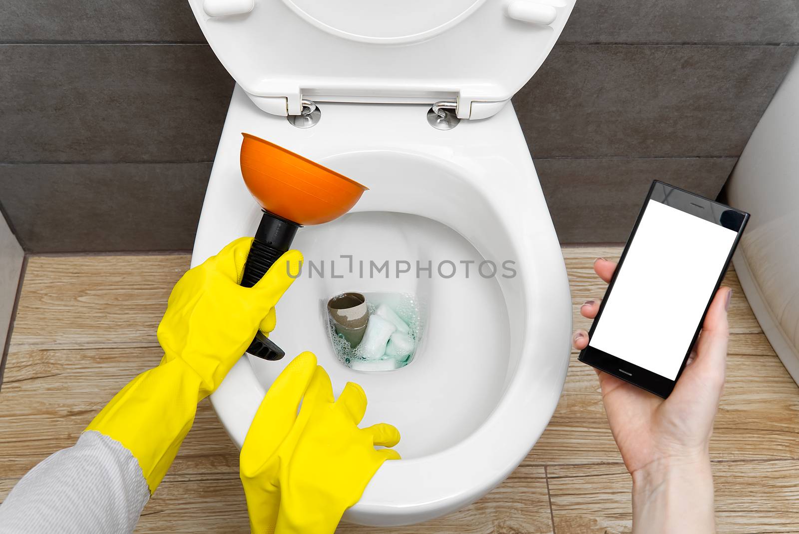 Overflowing broken toilet. clogged toilet. a smartphone with a white screen for advertising about plumbing. girl looking for help for an hour on the phone, mockup