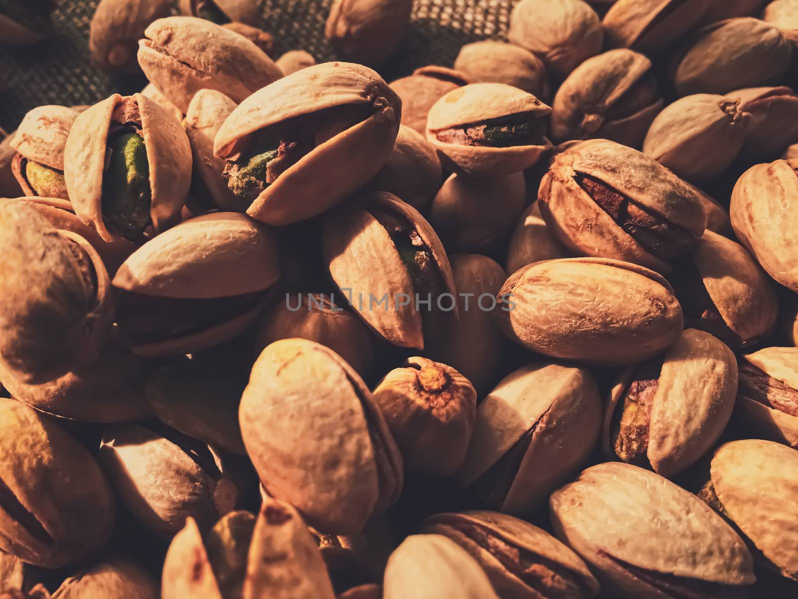 Pistachio nuts on rustic linen background, food and nutrition