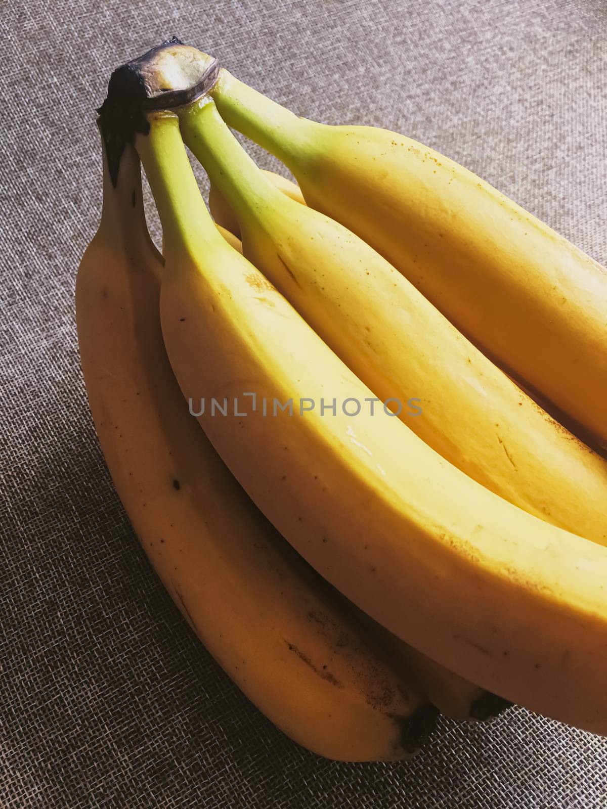 Organic bananas on rustic linen background by Anneleven