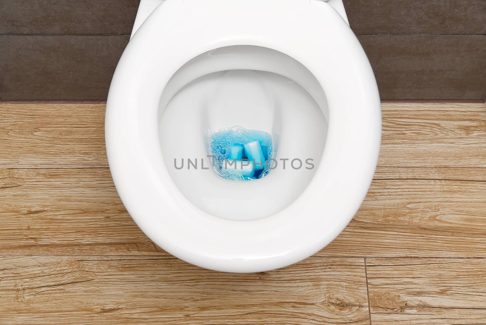 Close-up of a toilet clogged with hygiene products and toilet paper