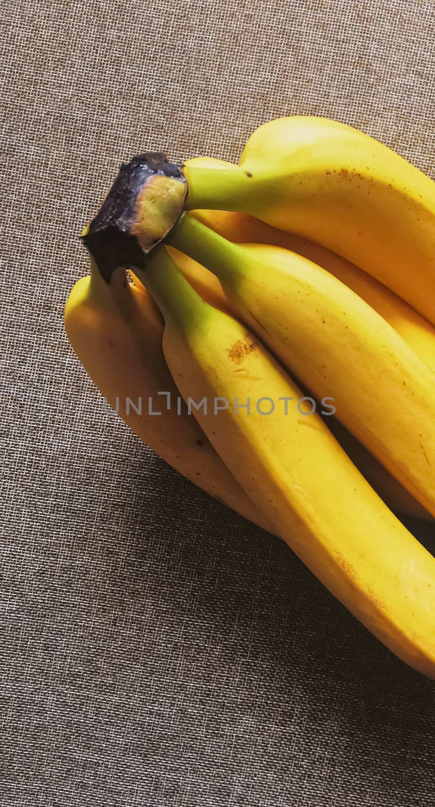 Organic bananas on rustic linen background by Anneleven