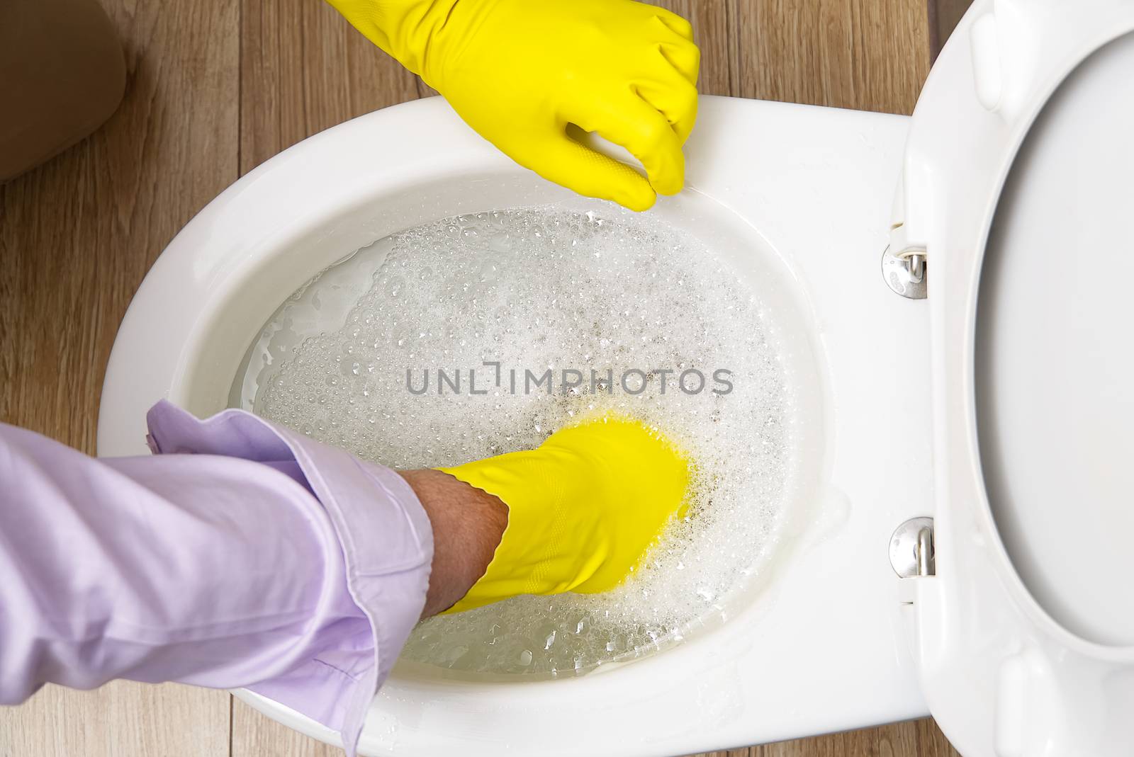 Man cleaning overflowing broken toilet. clogged toilet. by PhotoTime