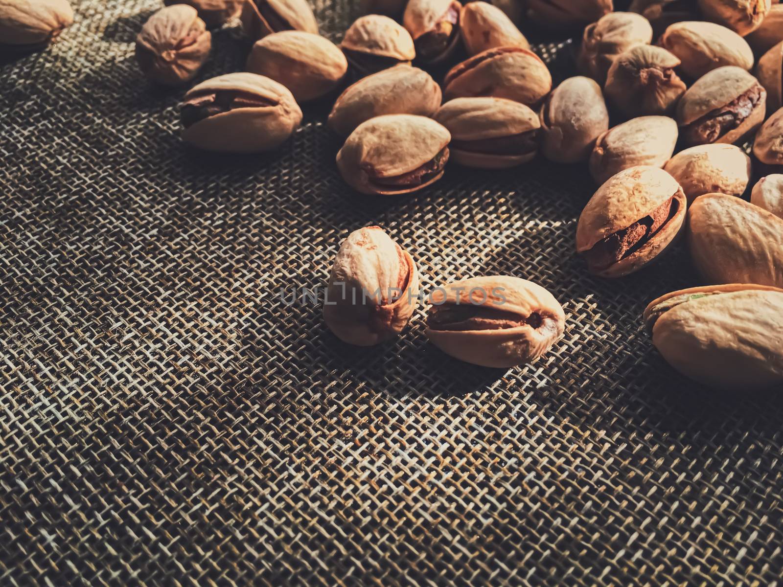 Pistachio nuts on rustic linen background by Anneleven