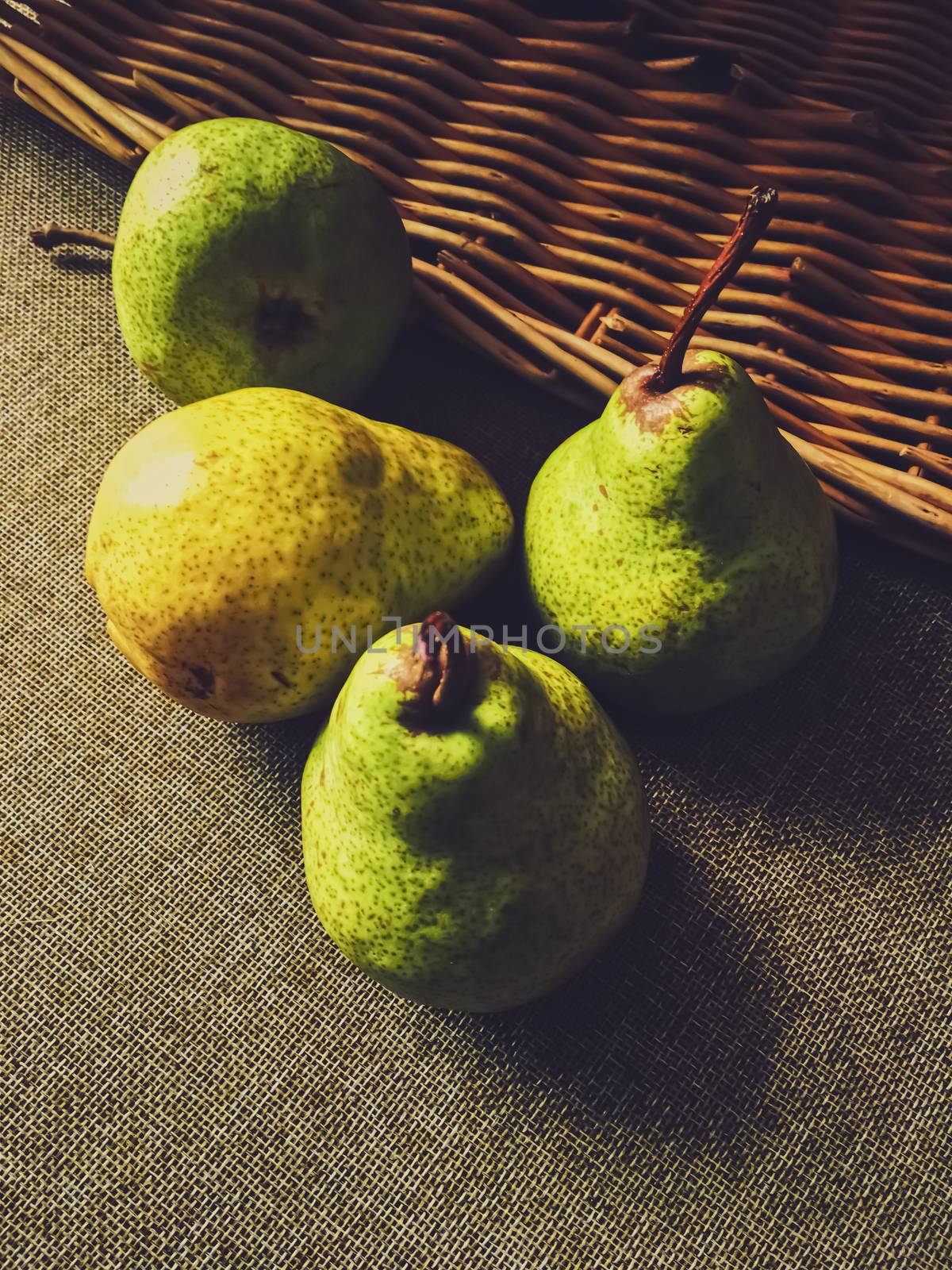 Organic pears on rustic linen background by Anneleven