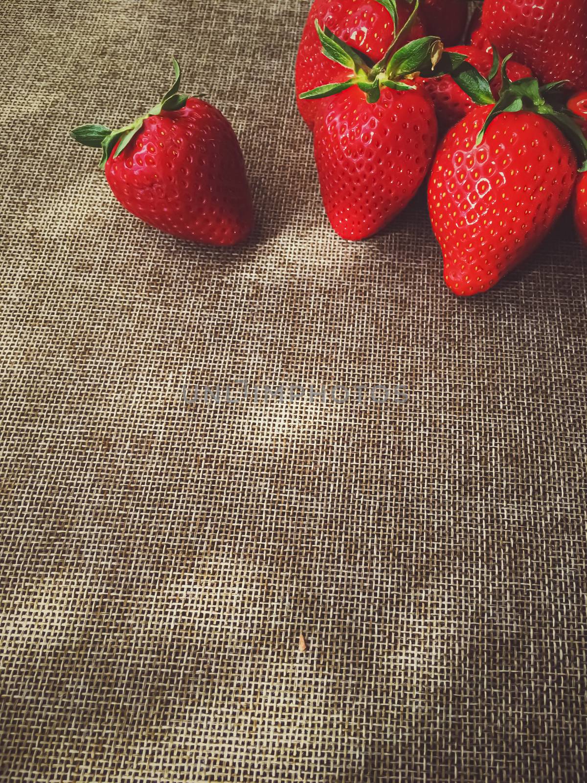 Organic strawberries on rustic linen background by Anneleven