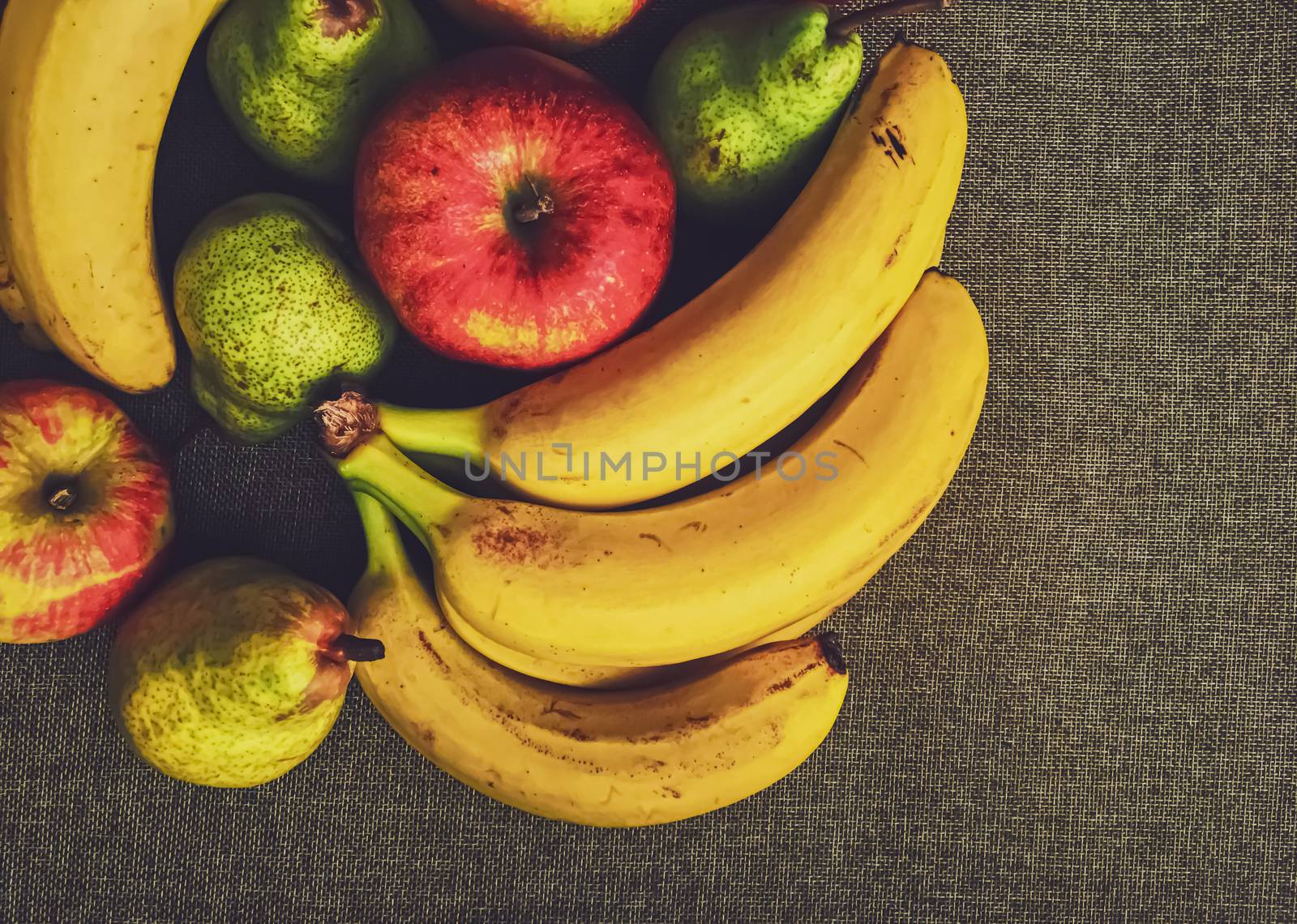 Organic apples, pears and bananas on rustic linen background by Anneleven