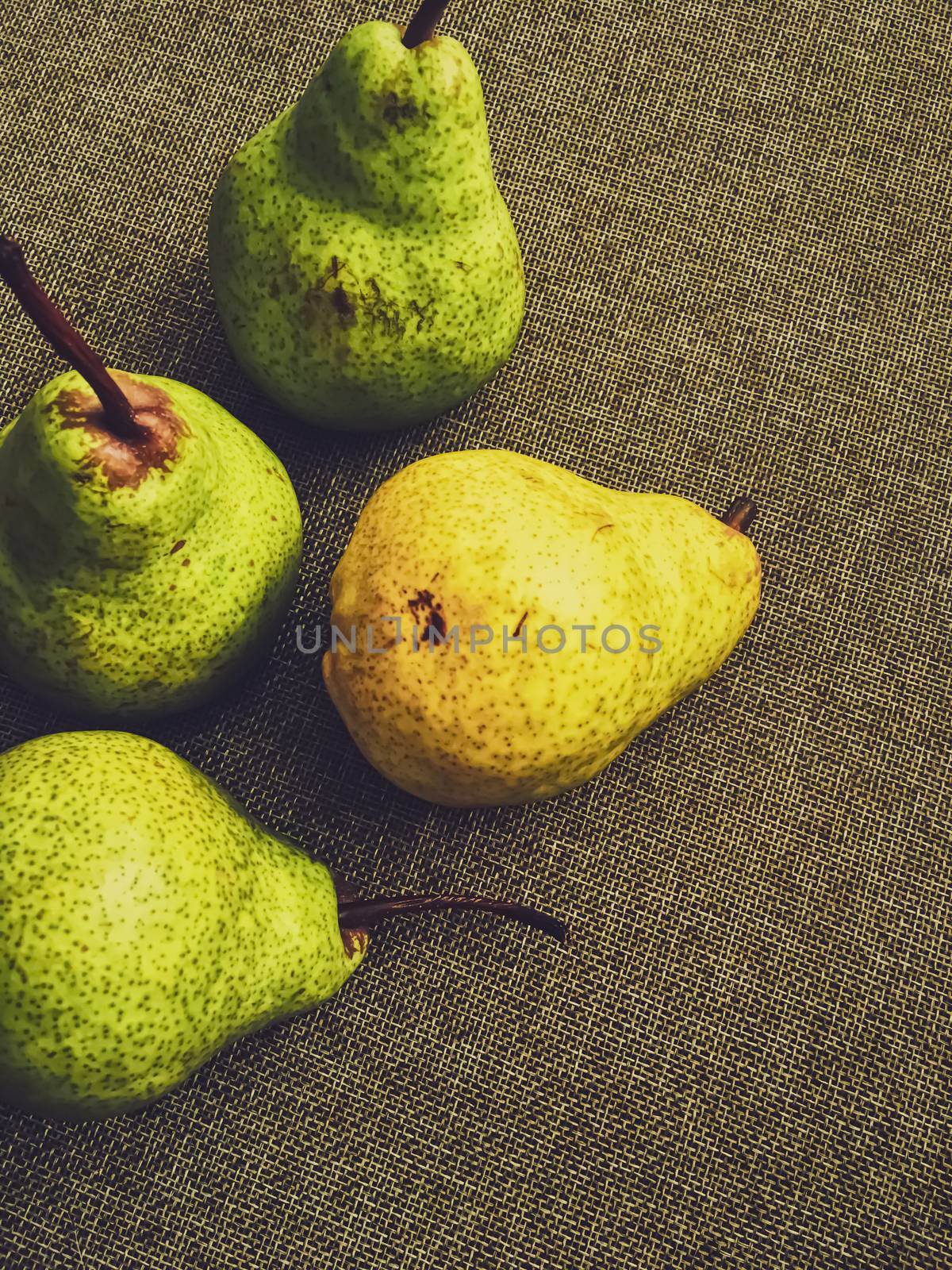 Organic pears on rustic linen background by Anneleven