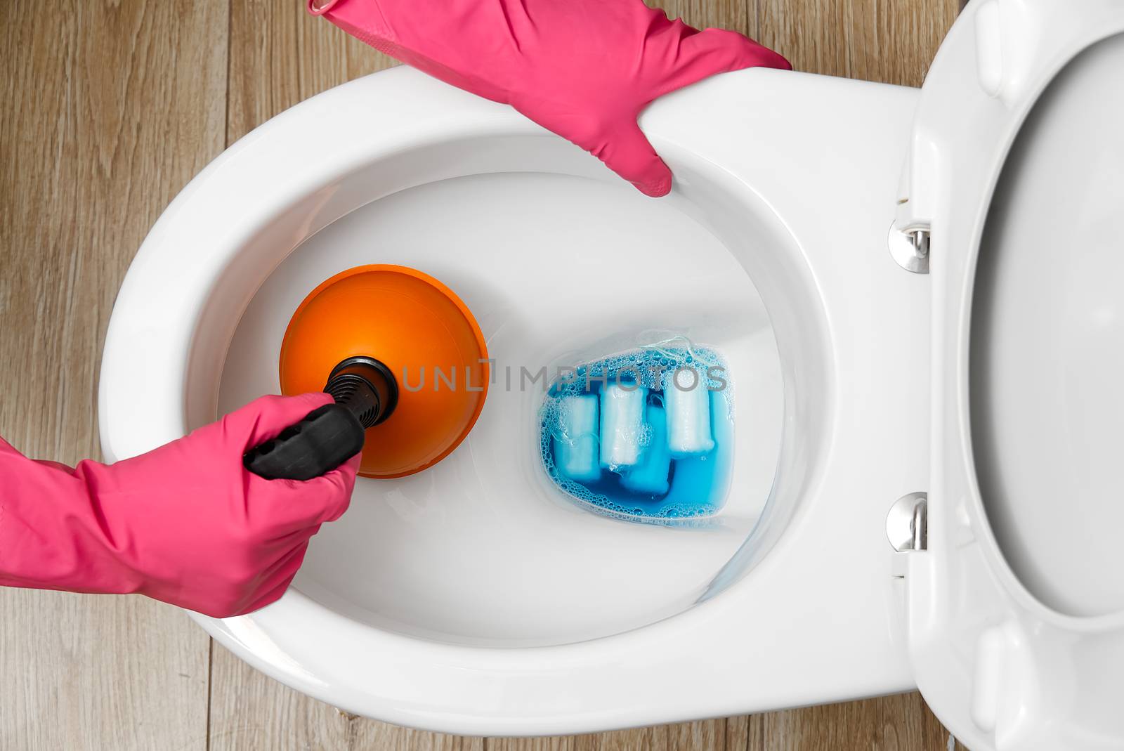 Women cleaning clogged toilet. broken overflowing toilet. home cleaning service concept. by PhotoTime