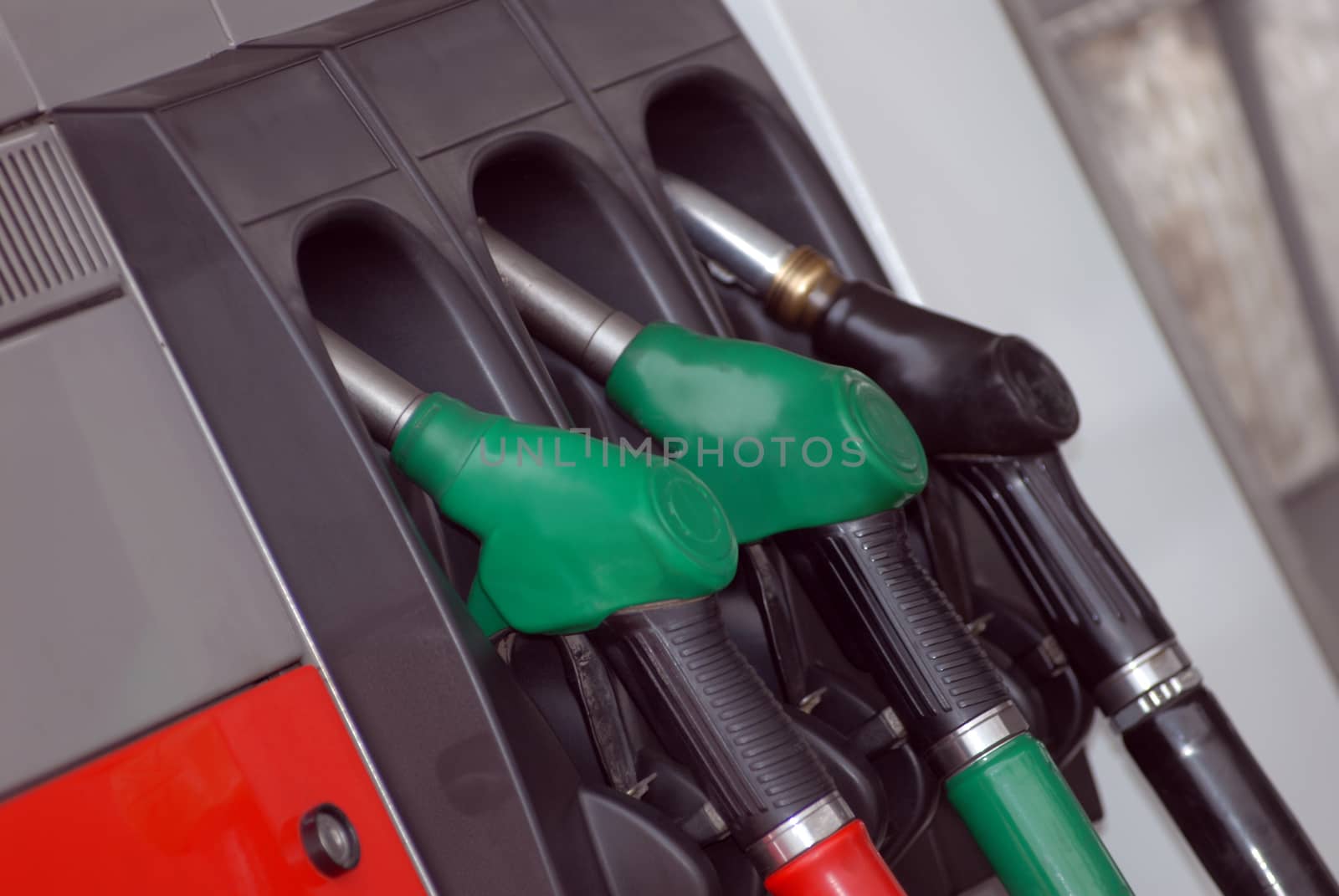 Three Gas pump nozzles on the petrol station