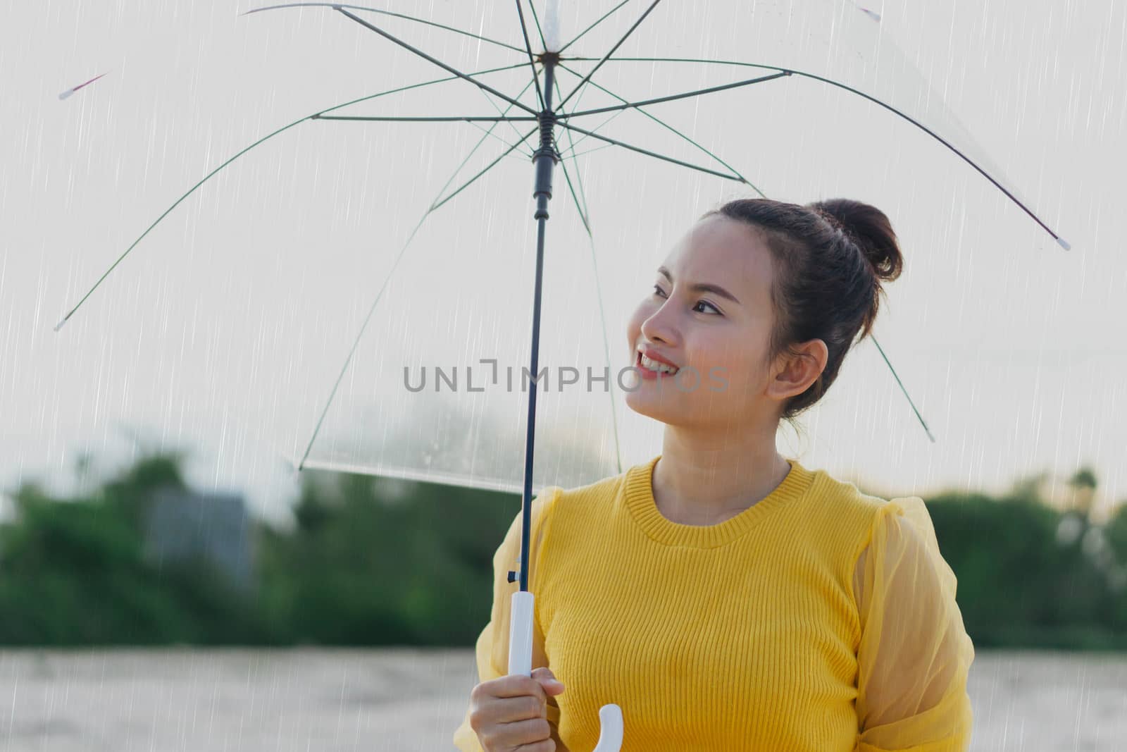 Closeup smiling and happy woman with umbrella in the rain season, vintage tone