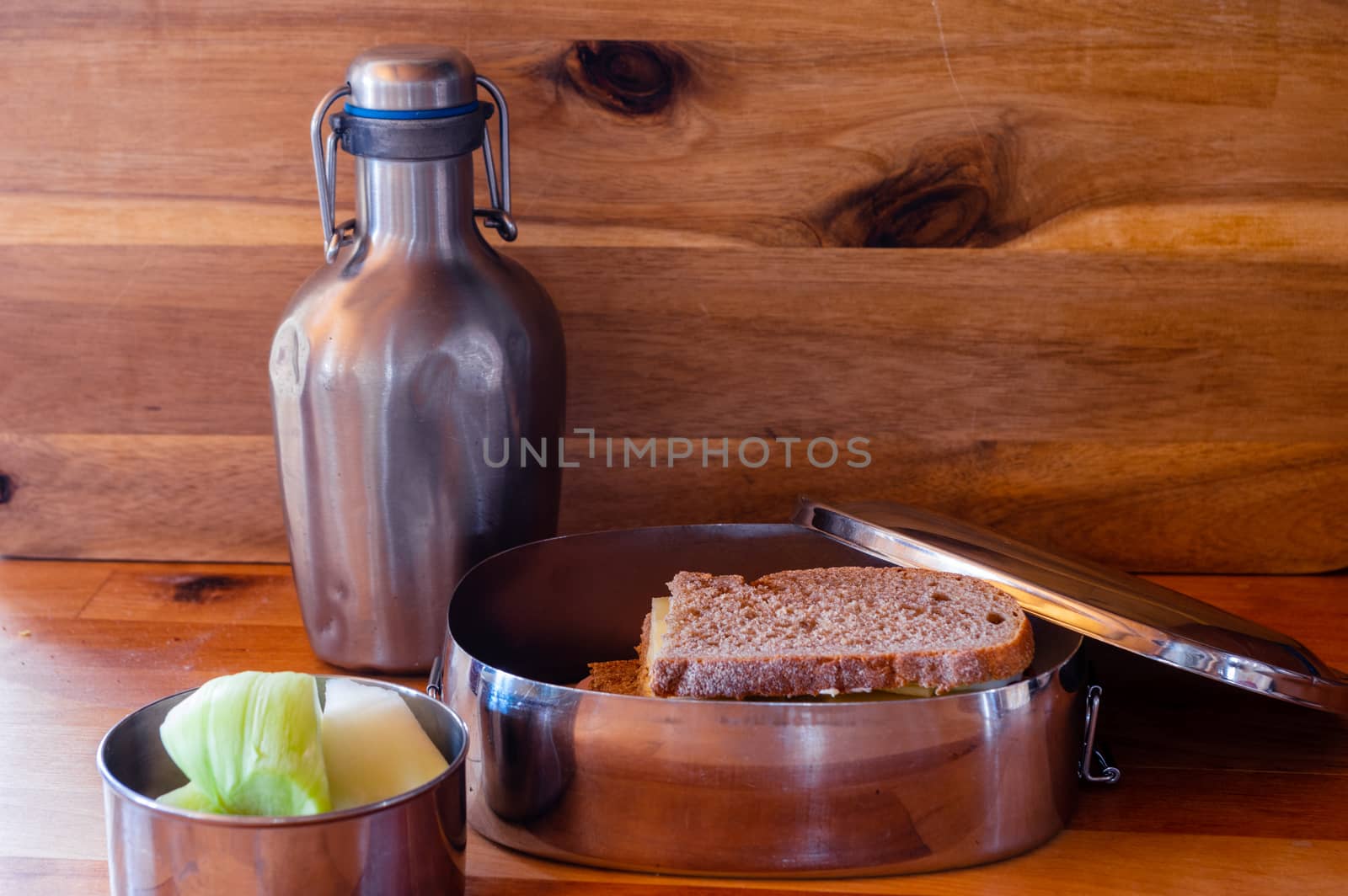 school lunch packed in stainless steel lunchbox on wooden surface