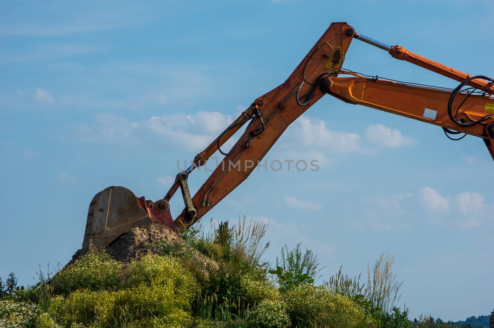 Excavator Arm against blue sky with clouds