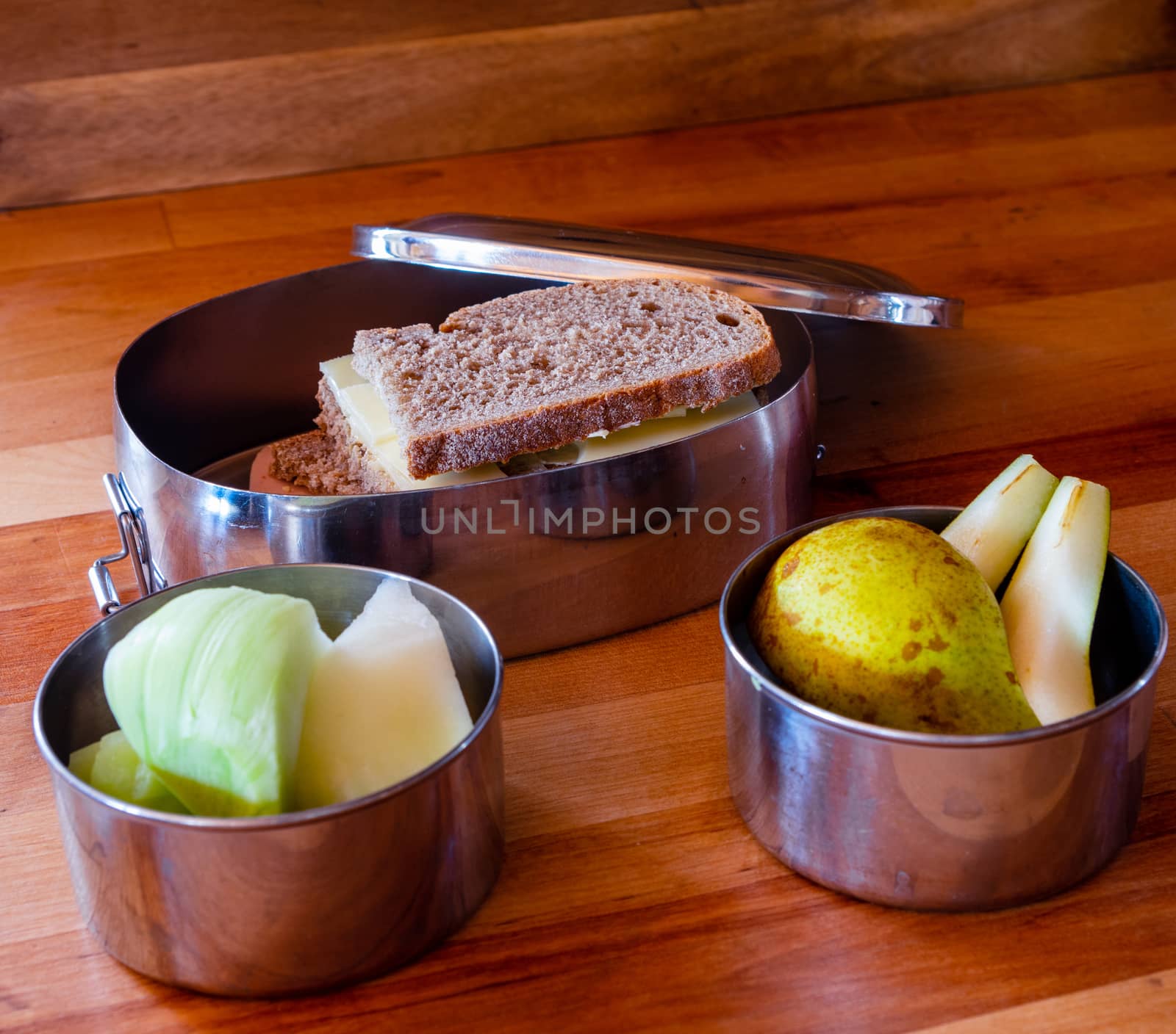 school lunch packed in stainless steel lunchbox on wooden surface