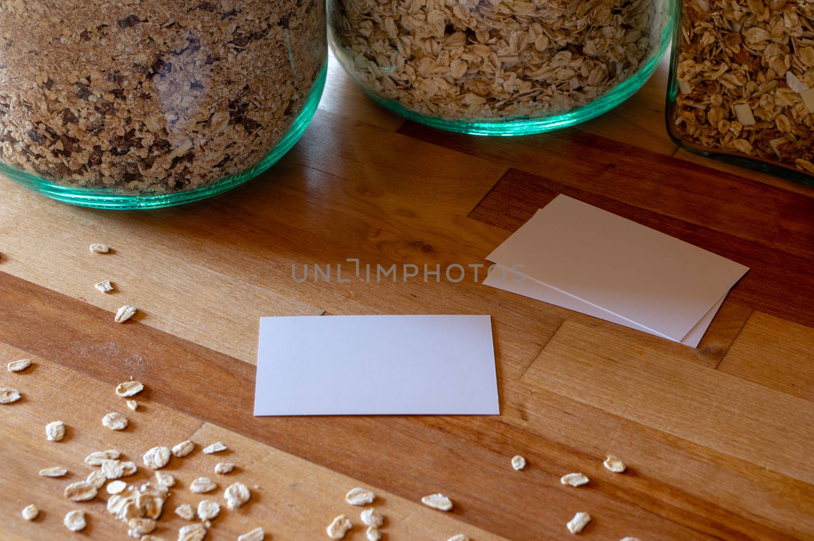 business card mockup templates on a table with sprinkled oatmeal - muesli jars in background by MarcoWarm