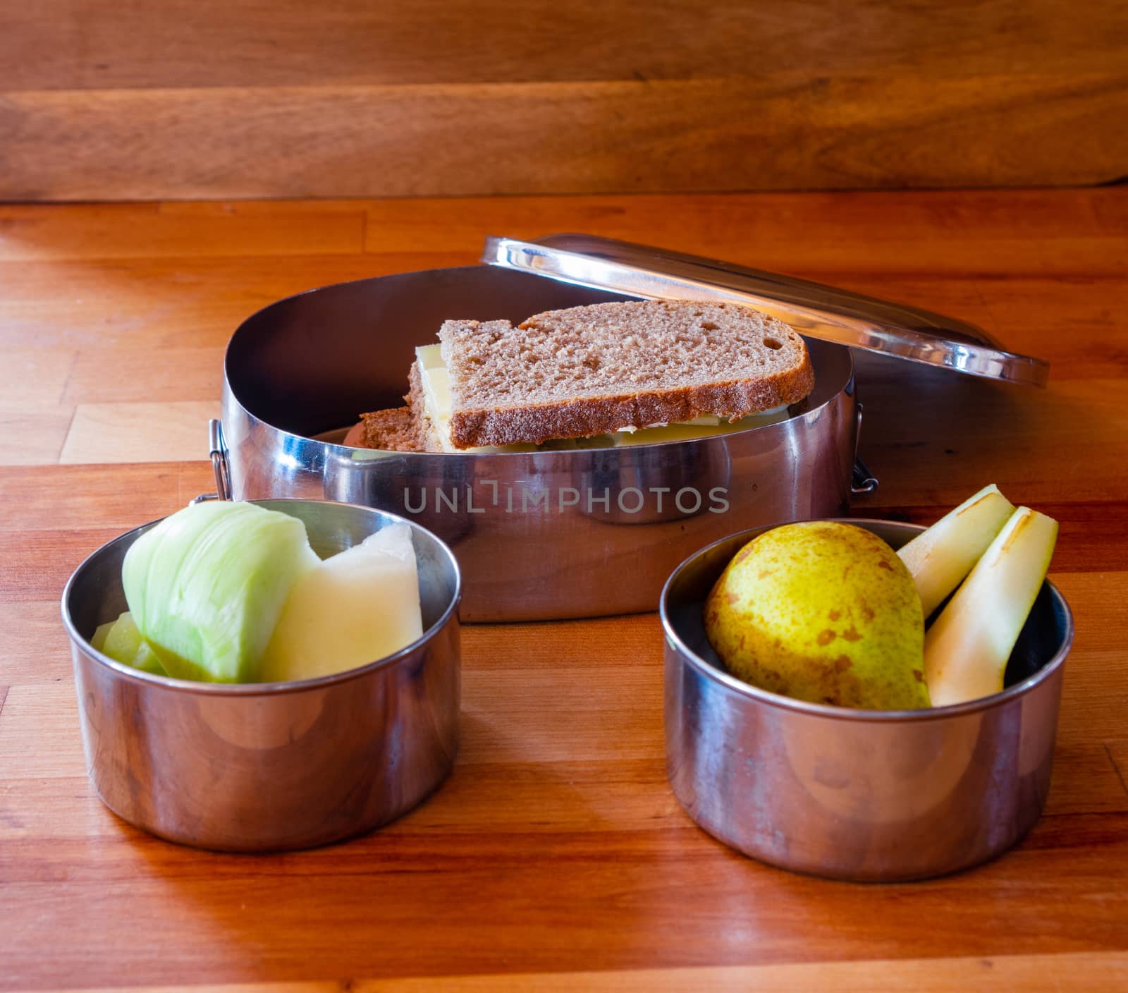school lunch packed in stainless steel lunchbox on wooden surface by MarcoWarm