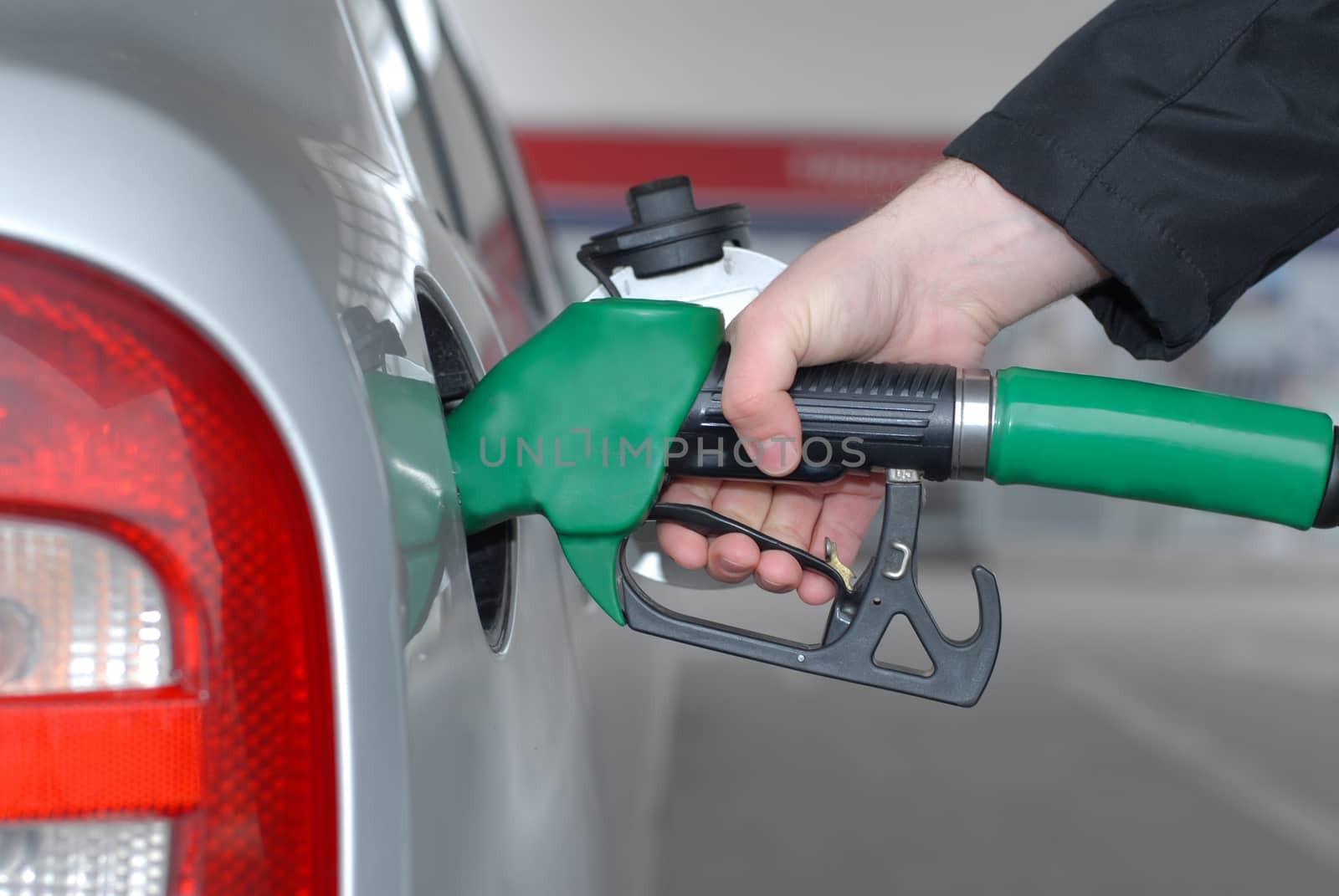 Male hand refilling the car with fuel on a filling station