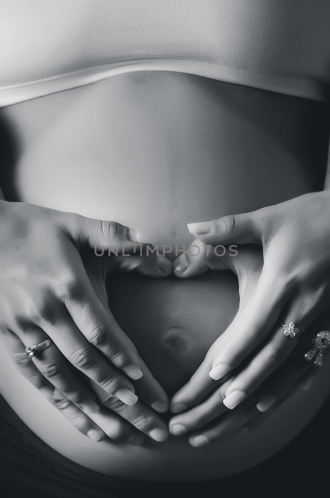 Cropped image of beautiful pregnant woman and her husband hugging the tummy