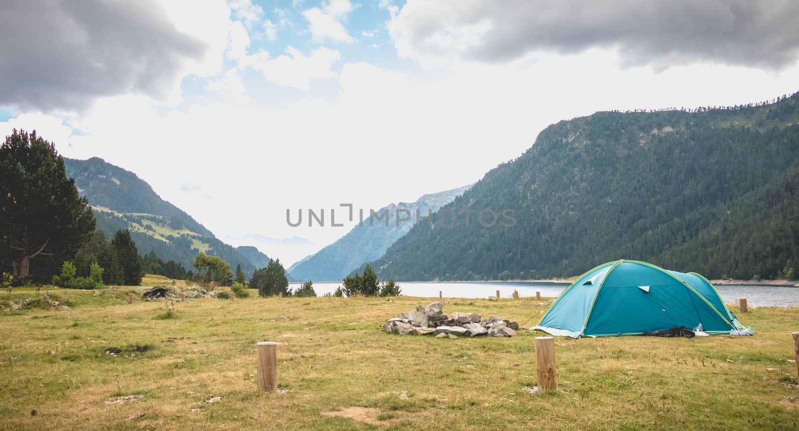 Wild camping atmosphere on a lake in the middle of the Pyrenees in France. with a tent, a gas rechaud