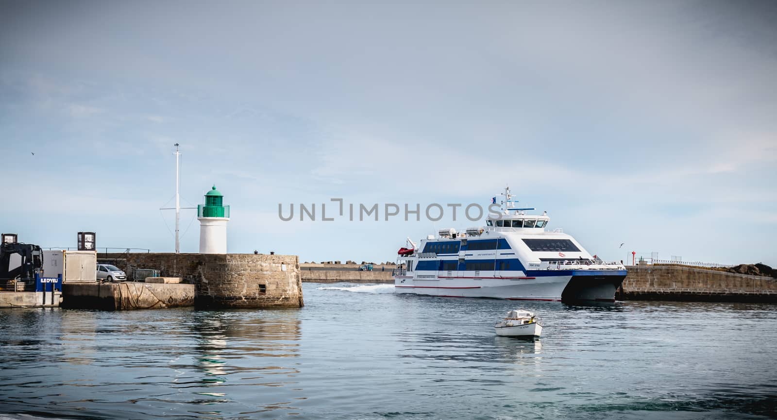 Ile d Yeu, France - September 16, 2018: ferry that enters the harbor of the island of Yeu where travelers are sitting to admire the show on a summer day