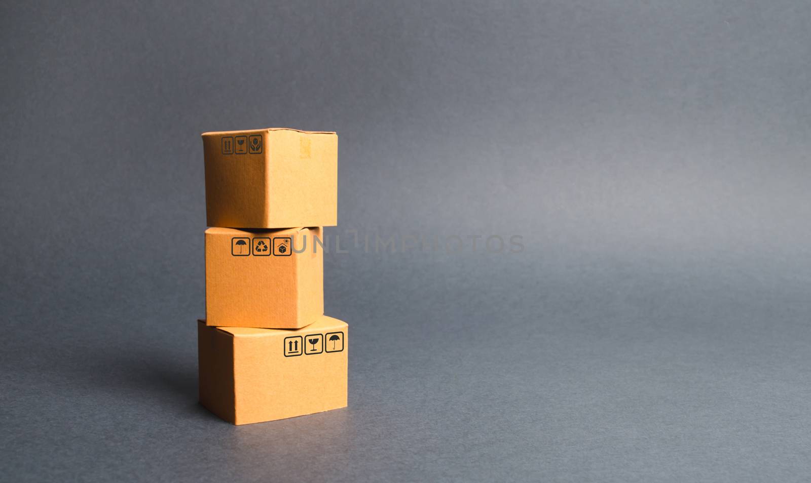 A bunch of three cardboard boxes. The concept of products and goods, commerce and retail. E-commerce, sales and sale of goods through online trading platform. Import and export of products