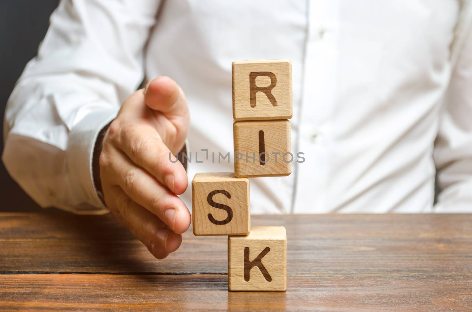 A man straightens a segment in an unstable tower of cubes labeled Risk. Risk management, cost assessment, and business and investment safety. Strengthen business resilience and flexibility.