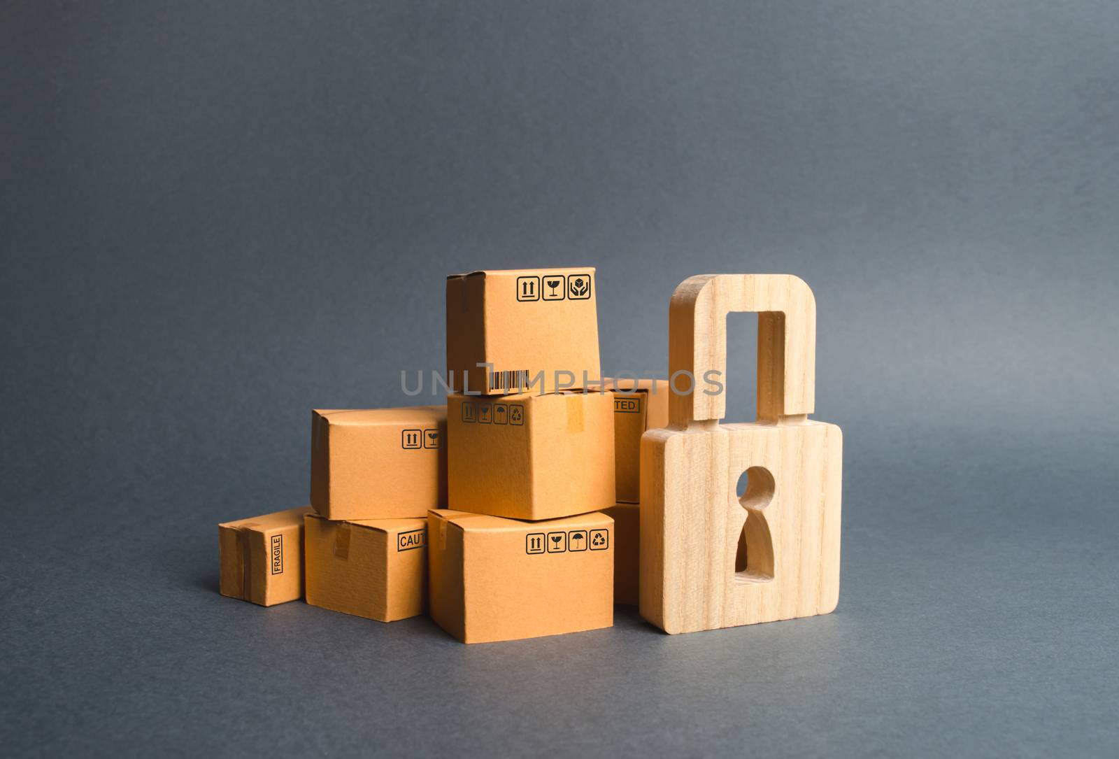 A pile of cardboard boxes and a wooden padlock. concept of insurance purchases. Providing warranty on purchased products. Consumer rights Protection. cargo arrest customs clearance. ban on the import. by iLixe48