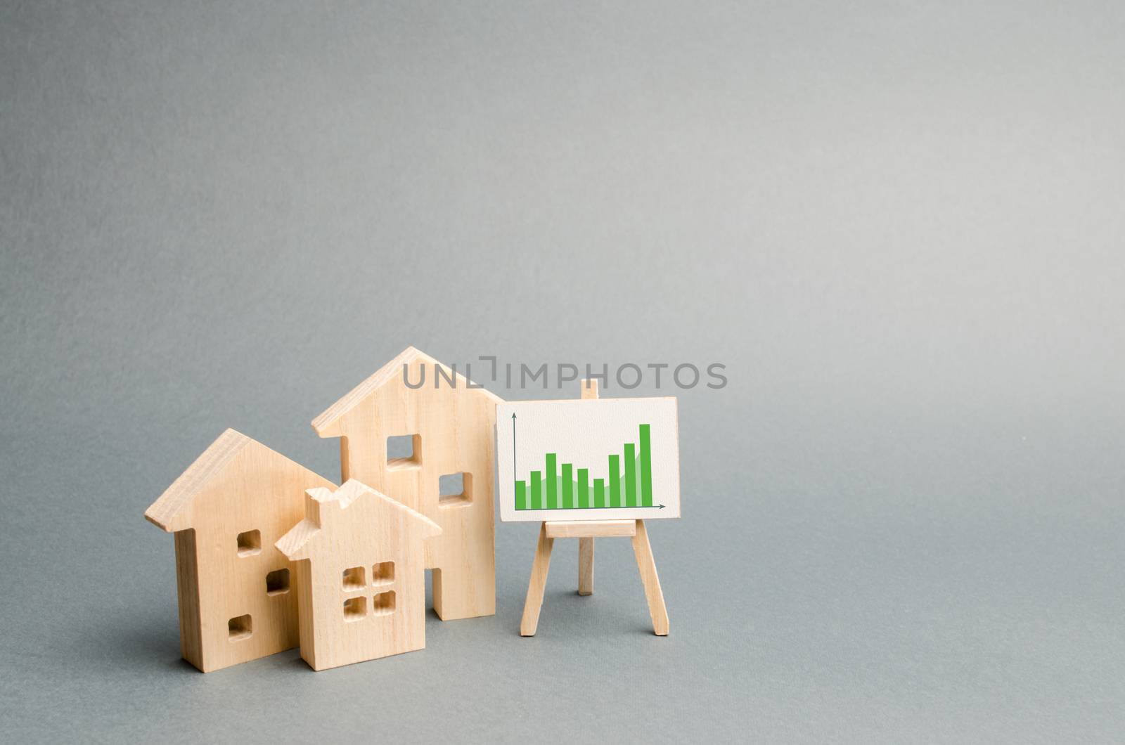 Wooden houses with a stand of graphics and information. Growing demand for housing and real estate. growth of the city and its population. Investments. rising prices for housing. Selective focus by iLixe48
