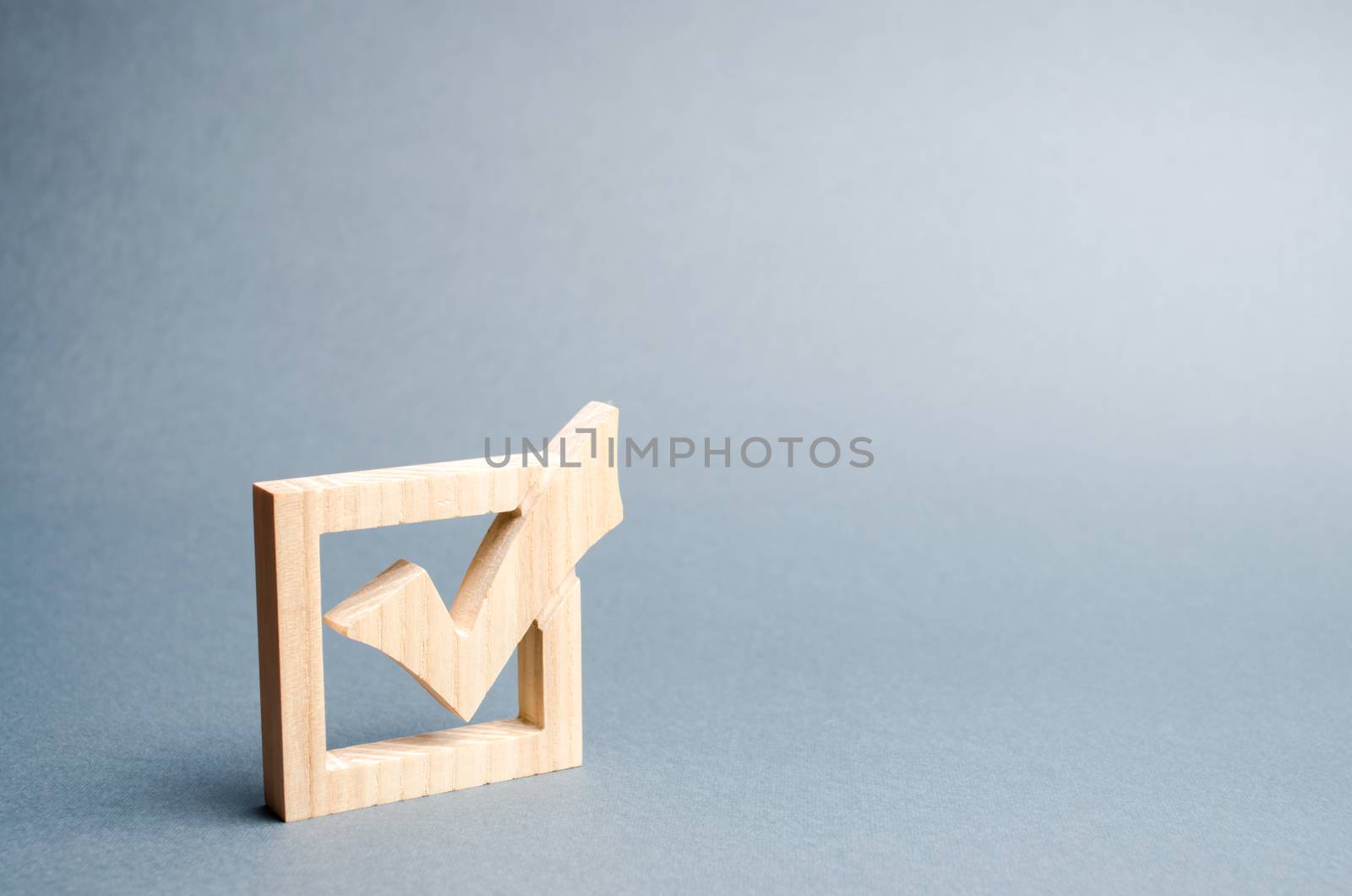 wooden checkmark for voting on elections on a gray background. Presidency or parliamentary elections, a referendum. Survey of the population, statistics, task. Democracy and freedom. Selective focus by iLixe48