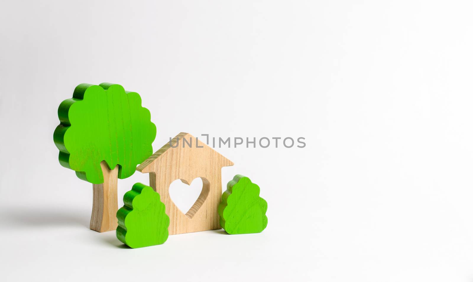 A house with a heart and wooden figures of trees with bushes. The concept of a love nest. Acquisition of affordable housing in a mortgage or loan. Accommodation for young families. Romantic gift. by iLixe48