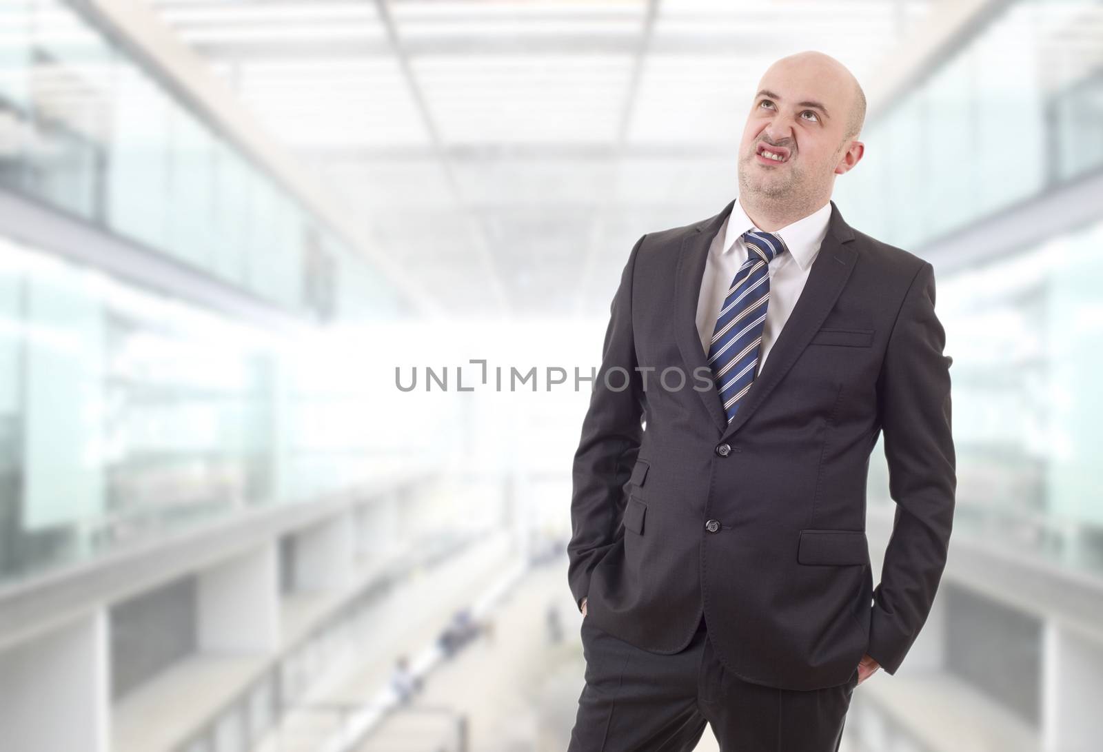 worried businessman in a suit looking up at the office