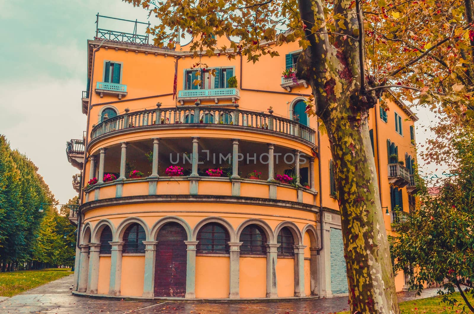 Old yellow house with a circular terrace, columns and an ancient entrance in Venice, Italy