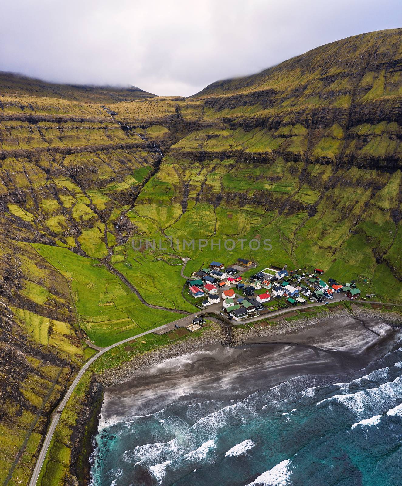 Aerial view of the Tjornuvik village and its beach located at a beautiful bay in the Faroe Islands, Denmark.