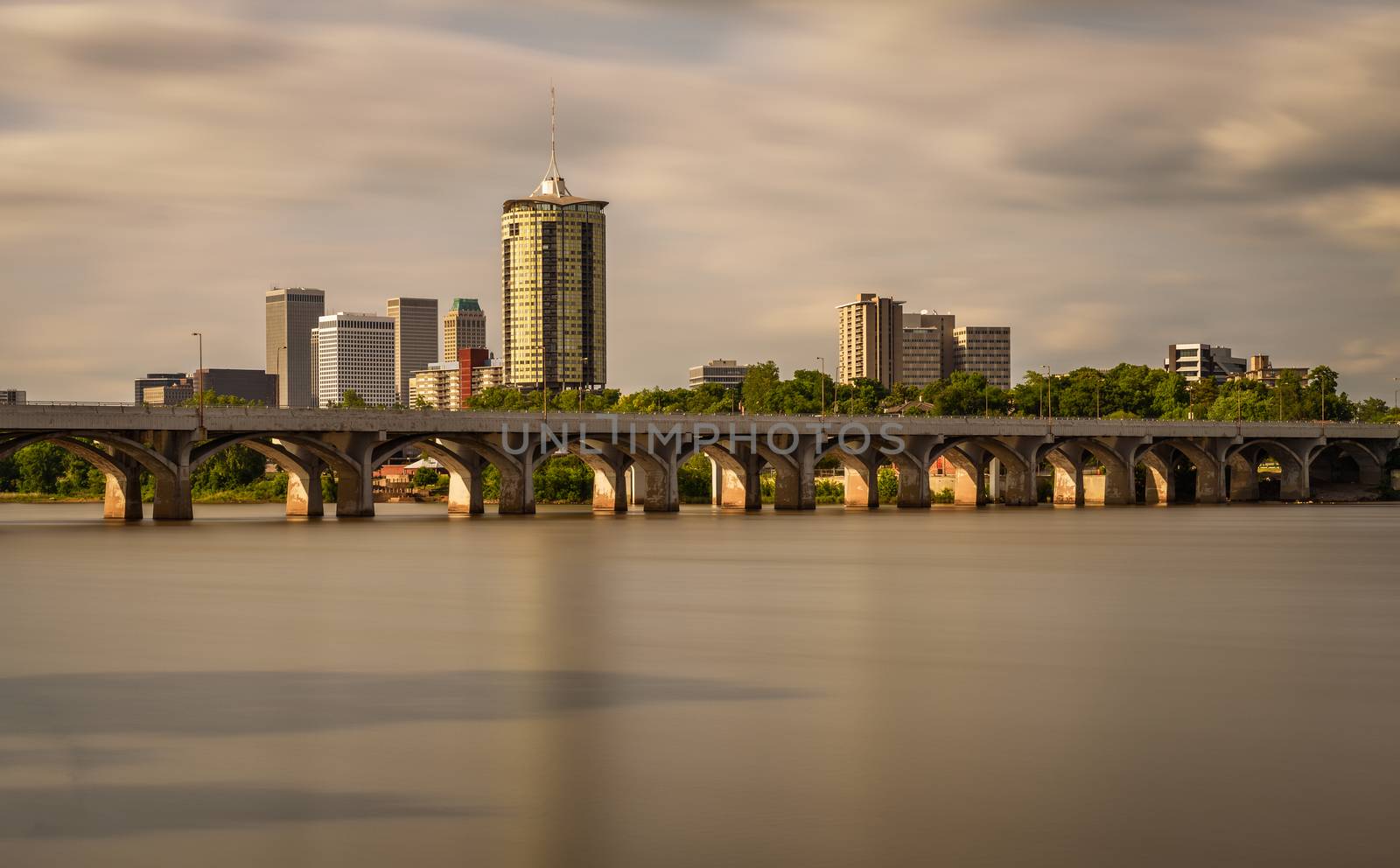 Sunset skyline of Tulsa, Oklahoma with Arkansas river in the foreground. Long exposure.