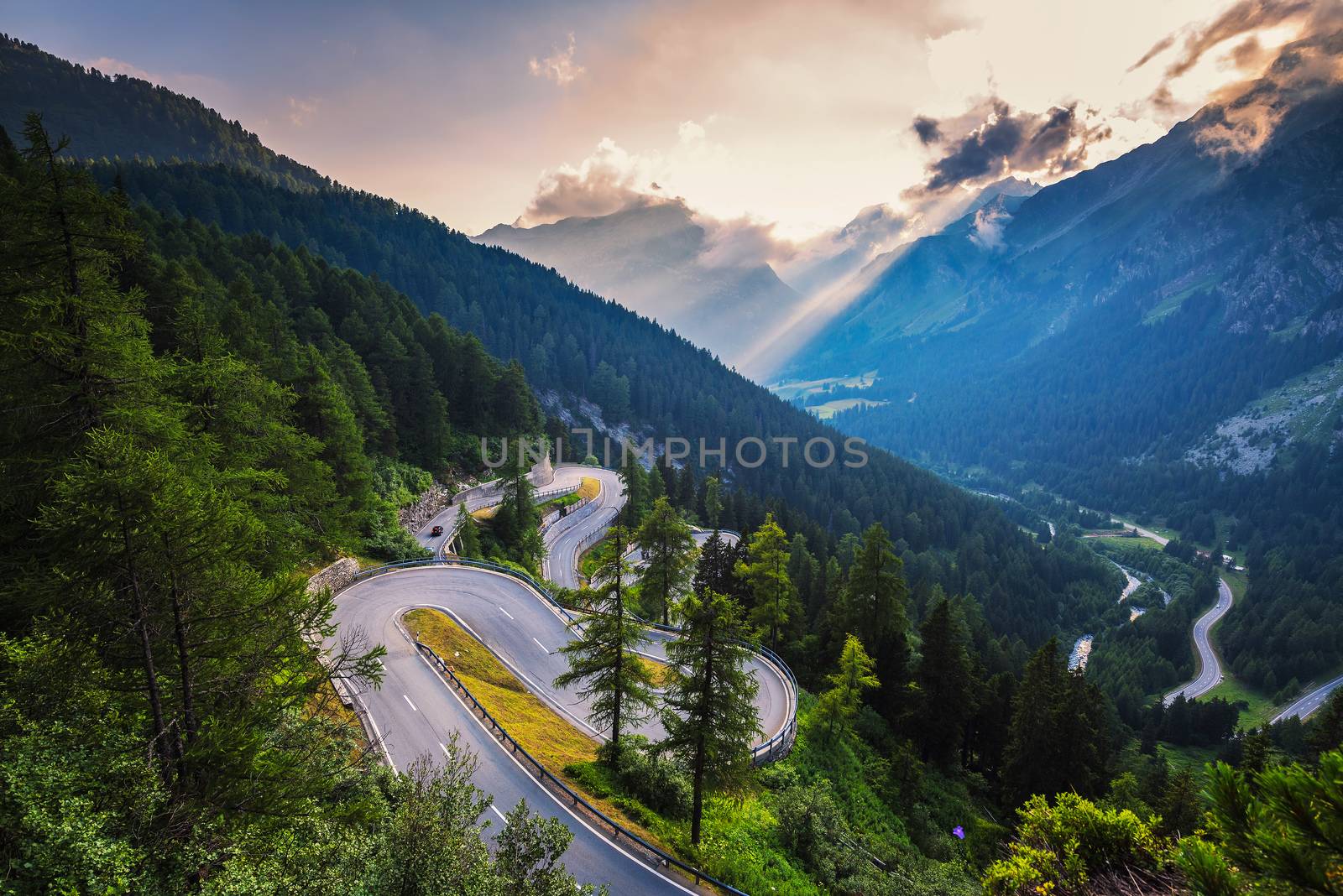 Aerial view of Maloja Pass road in Switzerland at sunset. This Swiss Alps mountain road is located in dense forests of the canton Graubunden.