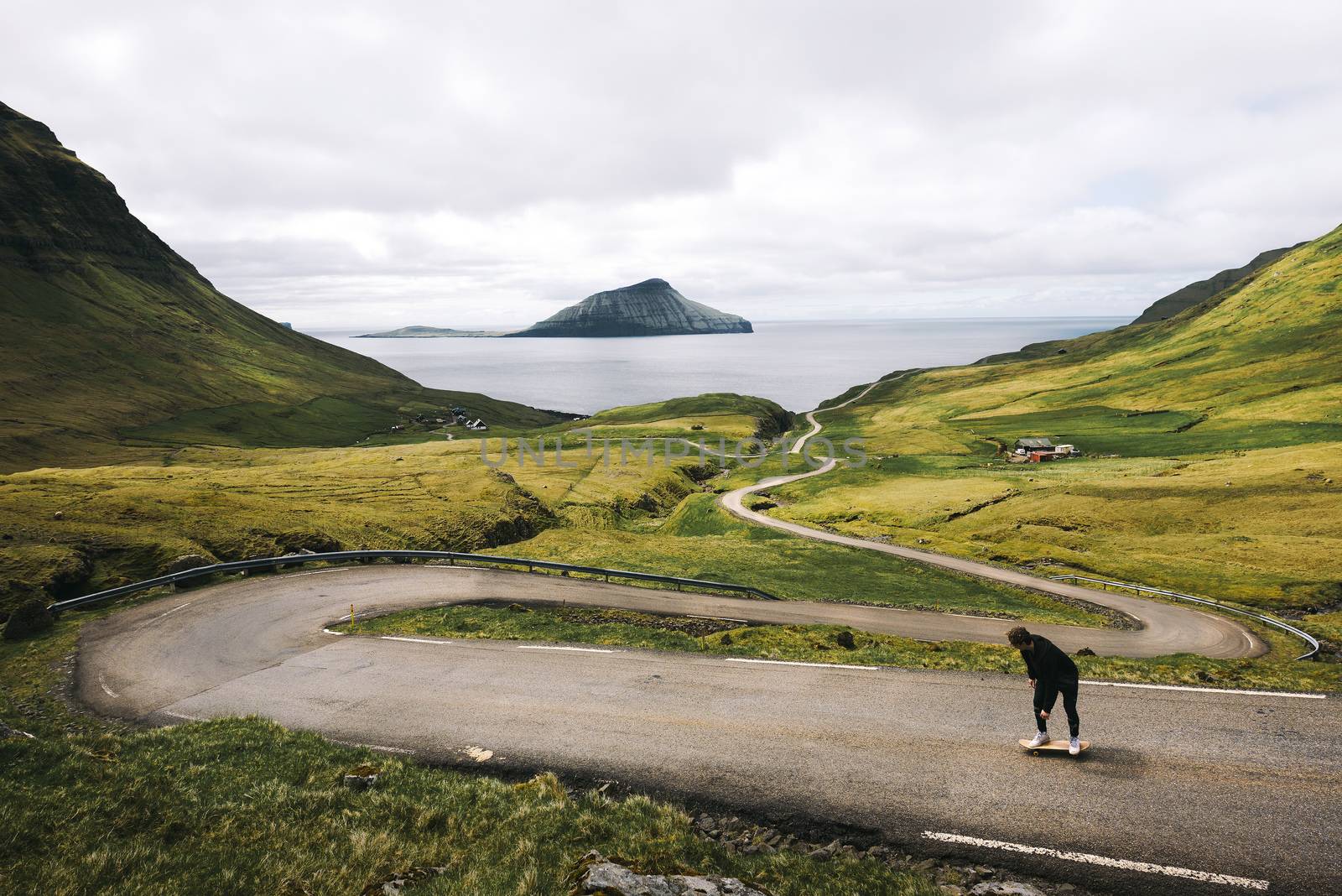 Young skater riding a skateboard through the beatiful scenery of Faroe Islands by nickfox