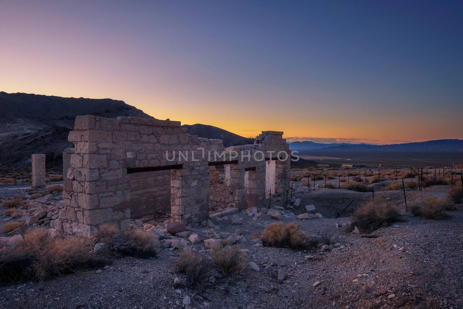 Sunrise above ruined building in the town of Rhyolite, Nevada. This ghost town is located in Nye County among Bullfrog Hills near Death Valley.