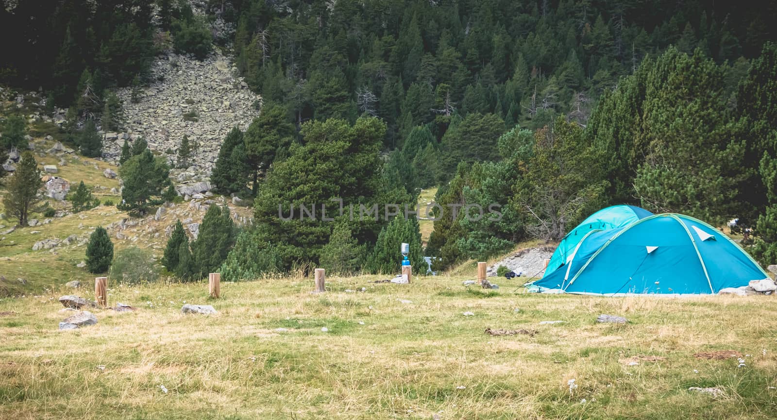Wild camping atmosphere on a lake in the middle of the Pyrenees in France. with a tent, a gas rechaud